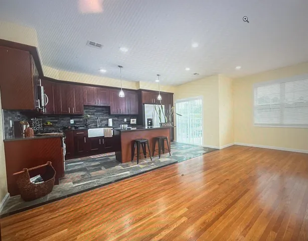 a kitchen with stainless steel appliances granite countertop a stove a sink and a refrigerator