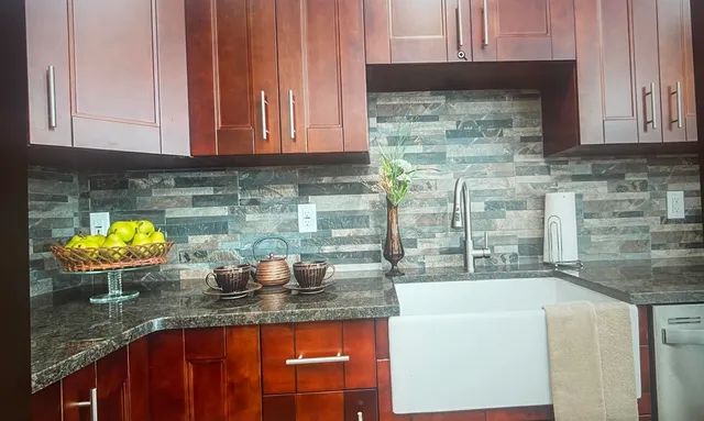 a kitchen with stainless steel appliances granite countertop a sink a stove and cabinets