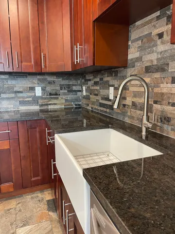 a kitchen with granite countertop a sink and a stove