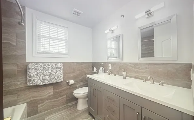 a bathroom with a sink toilet and mirror