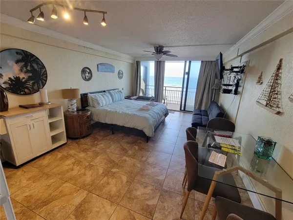 a bed room with a bed a television and couch