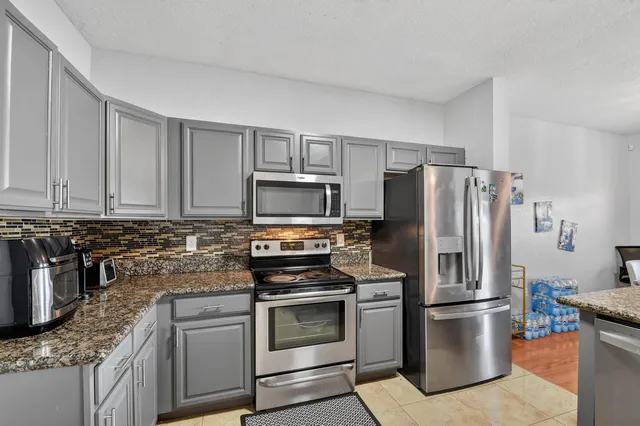 a kitchen with stainless steel appliances granite countertop a stove a refrigerator and a granite counter tops