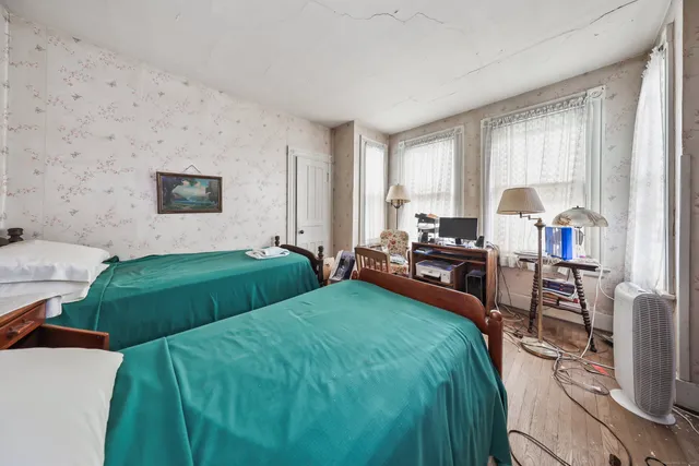 a bedroom with furniture and a wooden floor