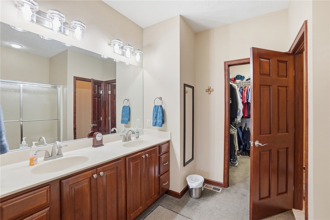 710 Governors Road Troy, OH 45373 - Photo 19 of 56 This spacious bathroom features a double vanity and an adjacent walk-in closet, offering comfort and convenience.