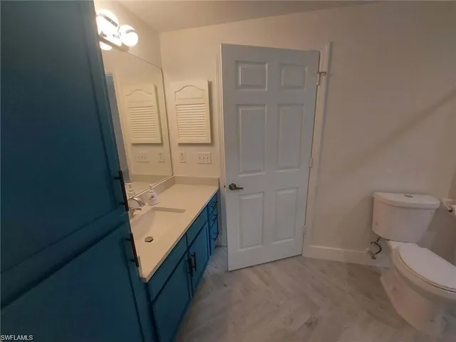 a bathroom with a granite countertop sink and toilet