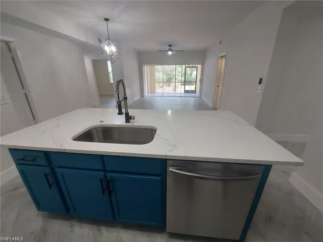 a kitchen with a sink and chandelier