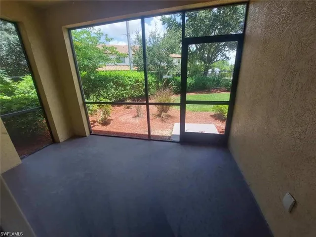 a view of an empty room with large windows