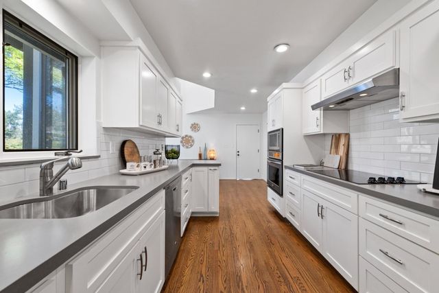 a kitchen with stainless steel appliances a sink stove and cabinets
