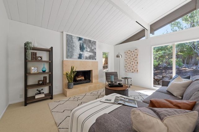 a bedroom with furniture a fireplace and a large window