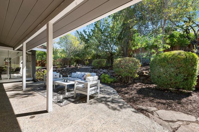 a view of a patio with table and chairs and potted plants