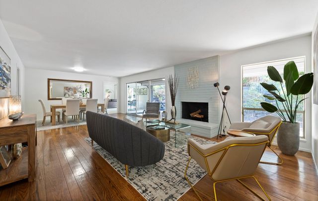 a living room with furniture a large window and a fireplace