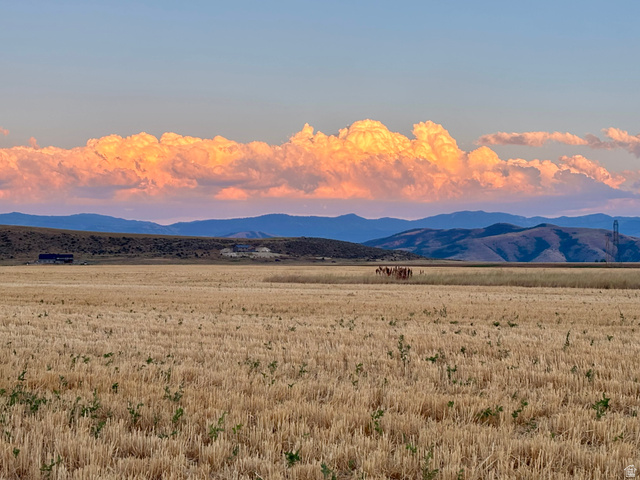 311 East Mail Rte Road Preston, ID 83263 - Photo 12 of 17 Expansive agricultural landscape featuring harvested fields, distant mountains, and a clear sky with prominent cloud formations