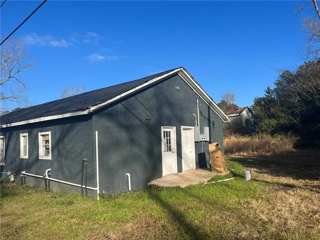 a backyard of a house with garage and barbeque oven