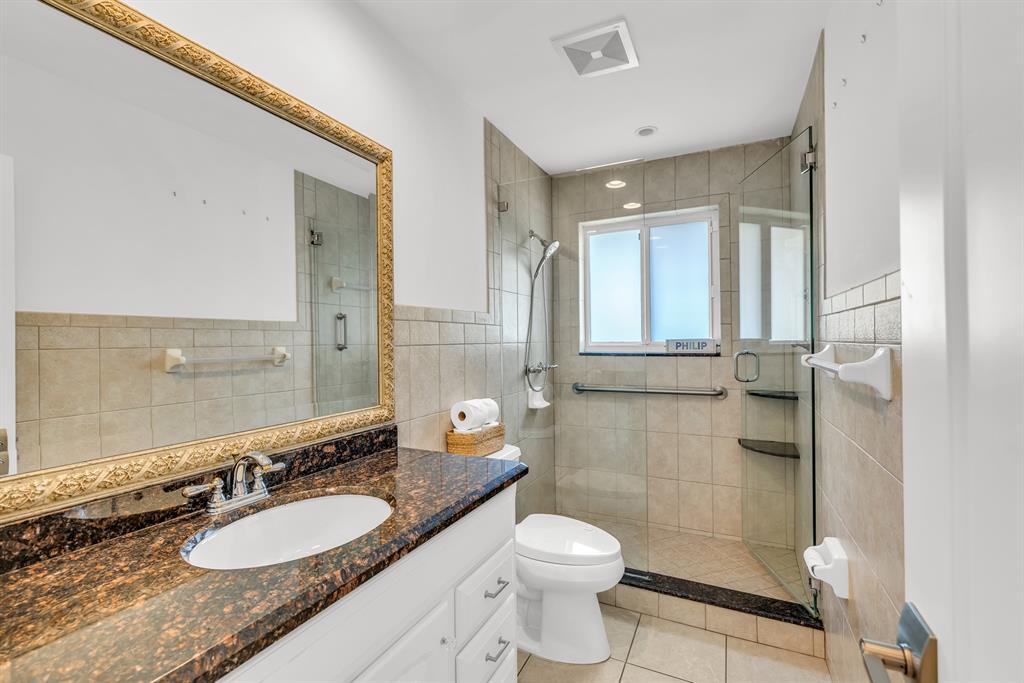 2800 Northeast 21st Avenue Lighthouse Point, FL 33064 - Photo 33 of 58 a bathroom with a granite countertop sink toilet mirror and shower