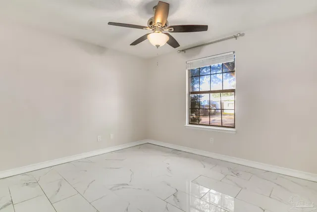an empty room with chandelier fan