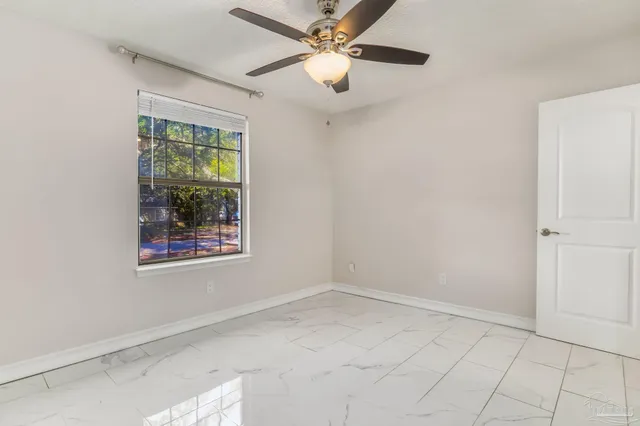 an empty room with a window and a fan