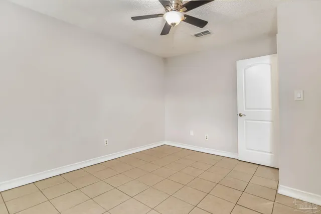 an empty room with a chandelier fan