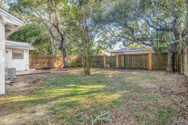 a view of a yard with a house and a large tree
