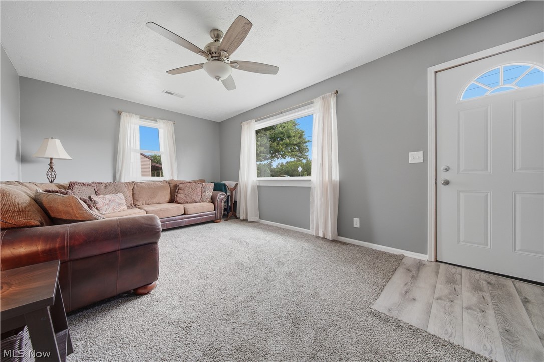 3471 State Rte 5 Newton Falls, OH 44444 - Photo 2 of 31 Spacious living area featuring light gray walls, plush gray carpeting, and multiple windows