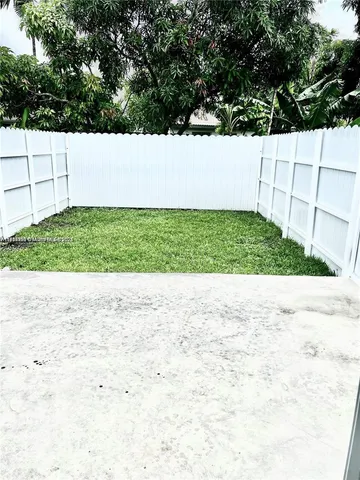 a view of yard with large trees