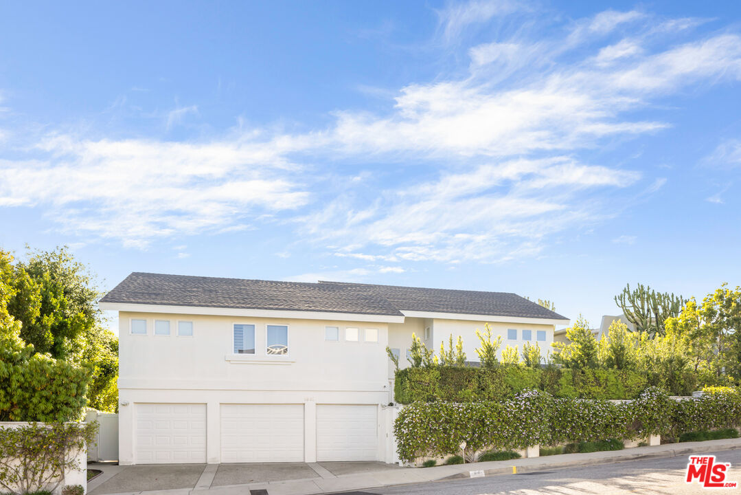 1641 Stradella Road Los Angeles, CA 90077 - Photo 19 of 23 a view of a white house next to a yard