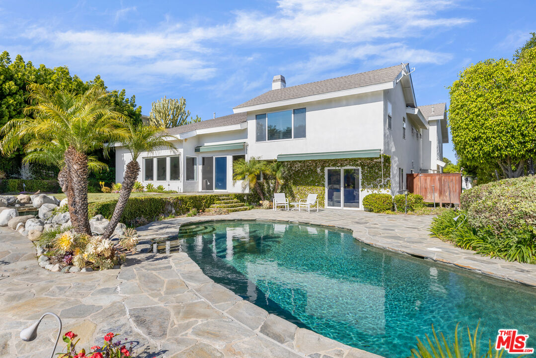 1641 Stradella Road Los Angeles, CA 90077 - Photo 2 of 23 a front view of a house with swimming pool having outdoor seating