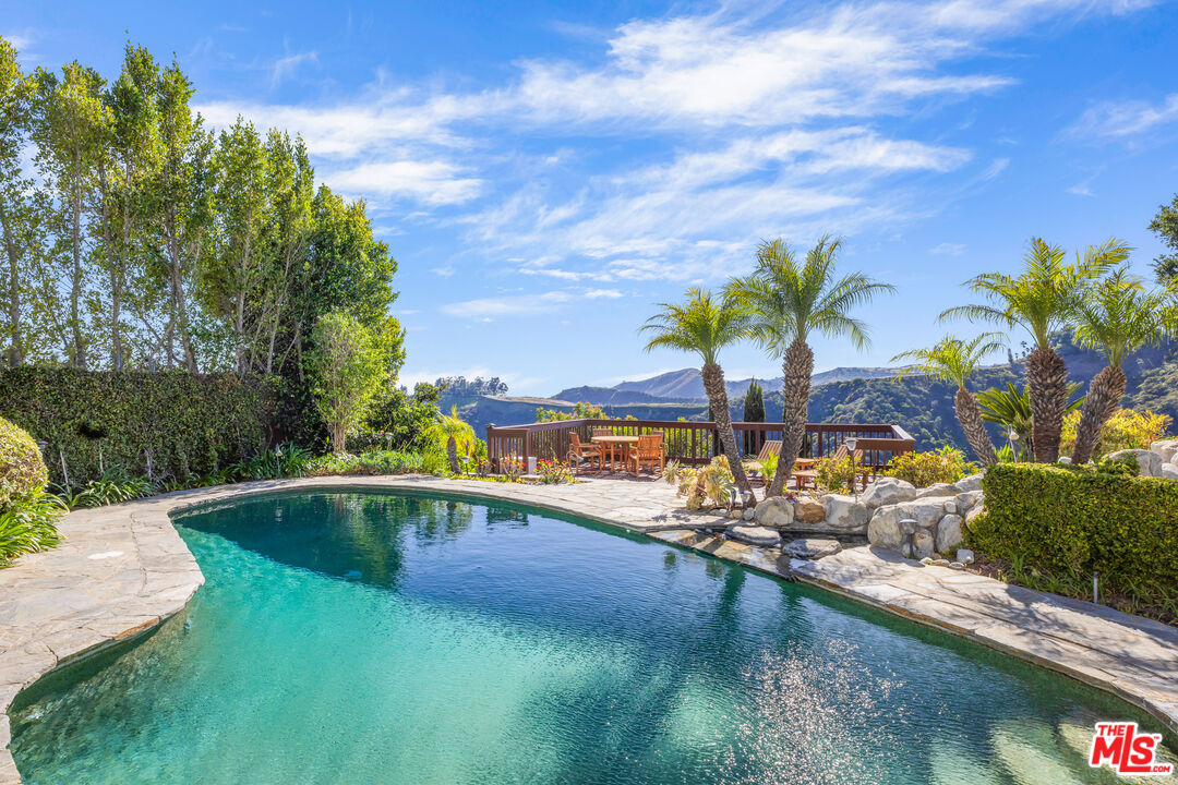 1641 Stradella Road Los Angeles, CA 90077 - Photo 3 of 23 a view of a swimming pool with a yard