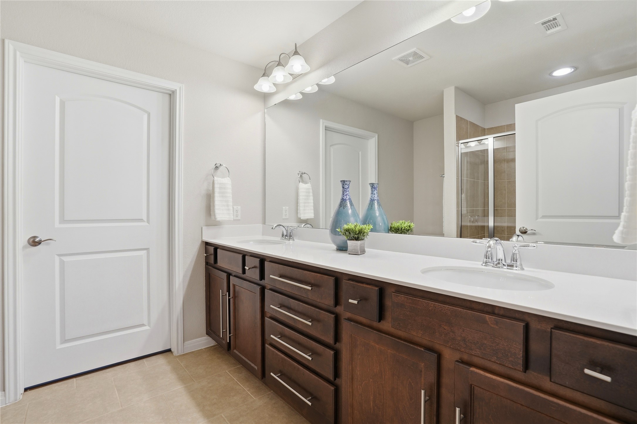 821 Hamilton Lane Georgetown, TX 78633 - Photo 13 of 38 Double vanity with a white countertop and integrated sinks, dark wood cabinetry