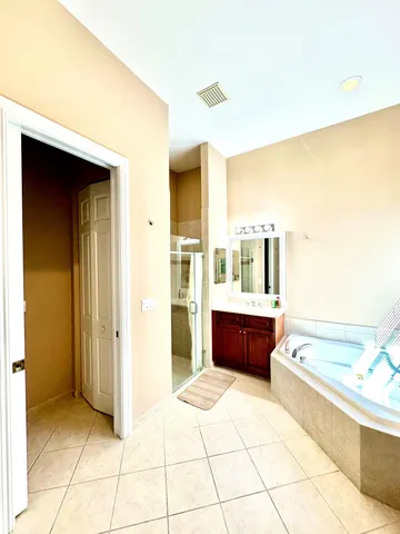 a spacious bathroom with a tub sink and mirror