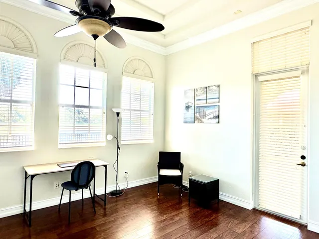 a view of a room with wooden floor table and windows