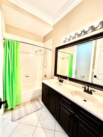 a bathroom with a double vanity sink a mirror and a bathtub