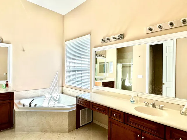 a bathroom with a tub sink and mirror