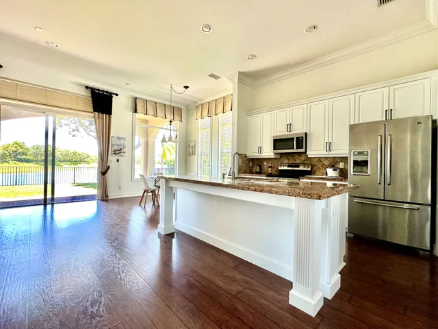 a kitchen with stainless steel appliances a refrigerator a stove a microwave and wooden floors