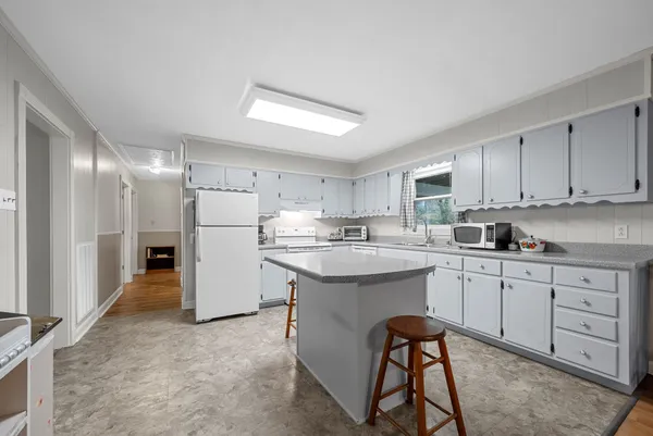 a kitchen with white cabinets and white appliances