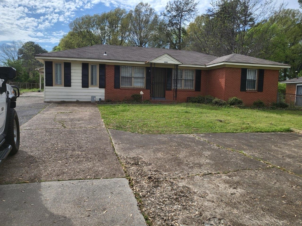 a front view of a house with a yard and trees