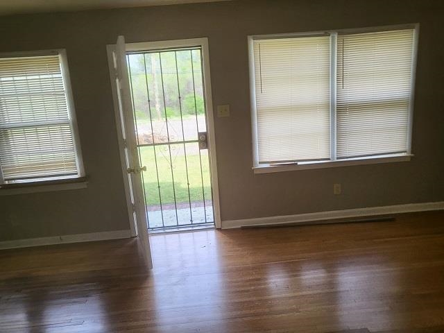 4985 Millbranch Road Memphis, TN 38116 - Photo 4 of 8 an empty room with wooden floor and windows