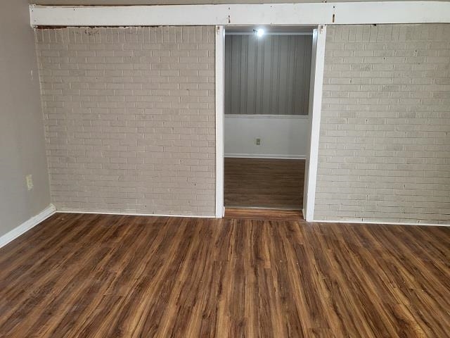 4985 Millbranch Road Memphis, TN 38116 - Photo 7 of 8 a view of an empty room with wooden floor and a bathroom