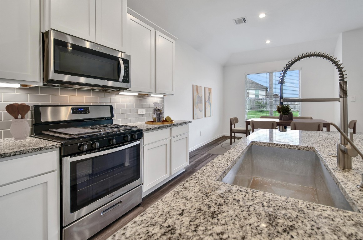 906 Youth Water Road Montgomery, TX 77316 - Photo 13 of 42 a kitchen with a stove a sink and a microwave