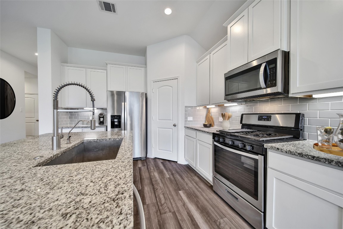 906 Youth Water Road Montgomery, TX 77316 - Photo 15 of 42 a kitchen with stainless steel appliances granite countertop a stove a refrigerator and a sink