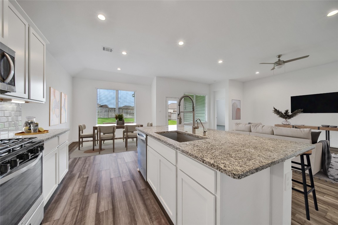 906 Youth Water Road Montgomery, TX 77316 - Photo 16 of 42 a kitchen with a stove and a wooden floor
