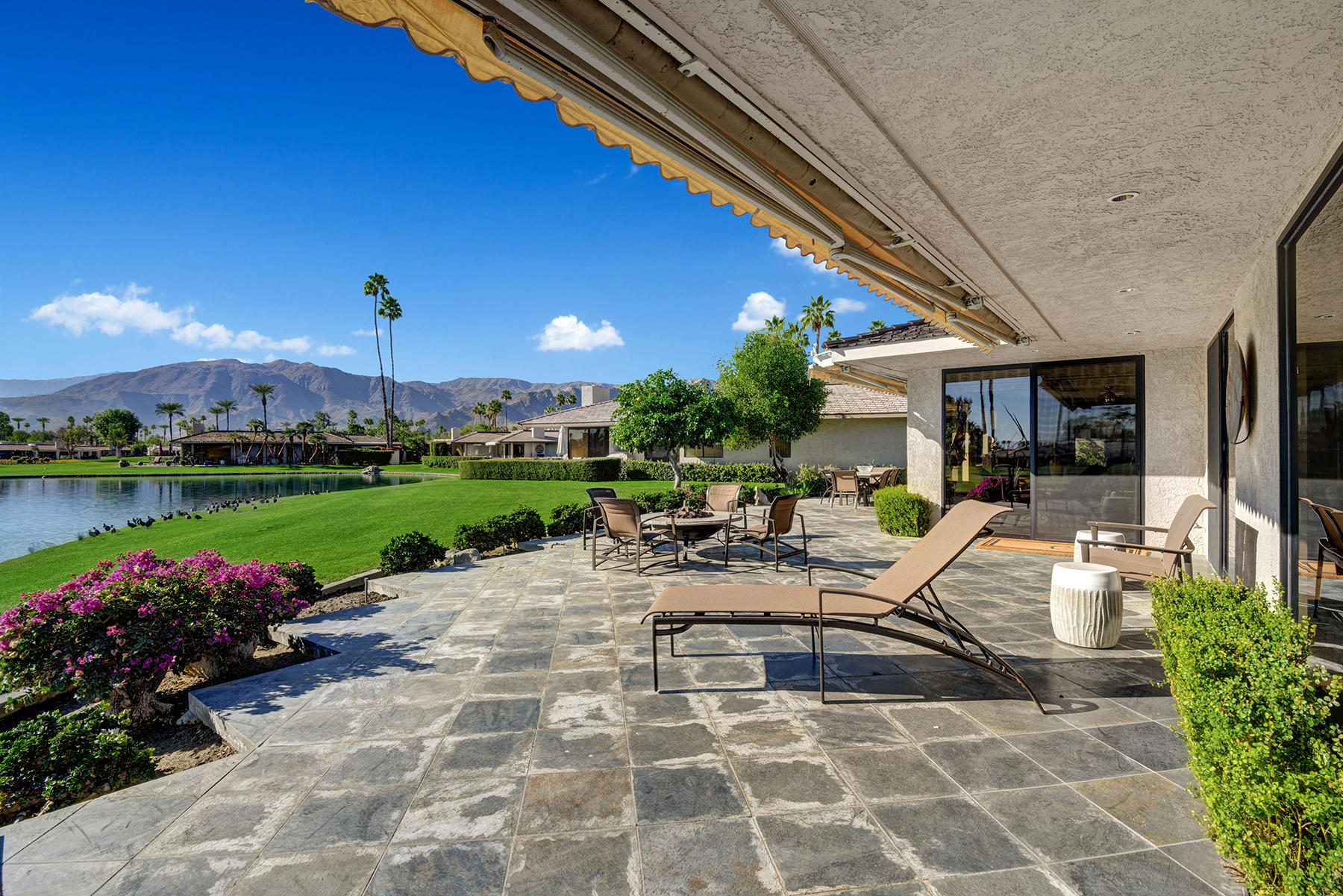 8 Rutgers Court Rancho Mirage, CA 92270 - Photo 46 of 57 a view of a patio with table and chairs potted plants and a palm tree