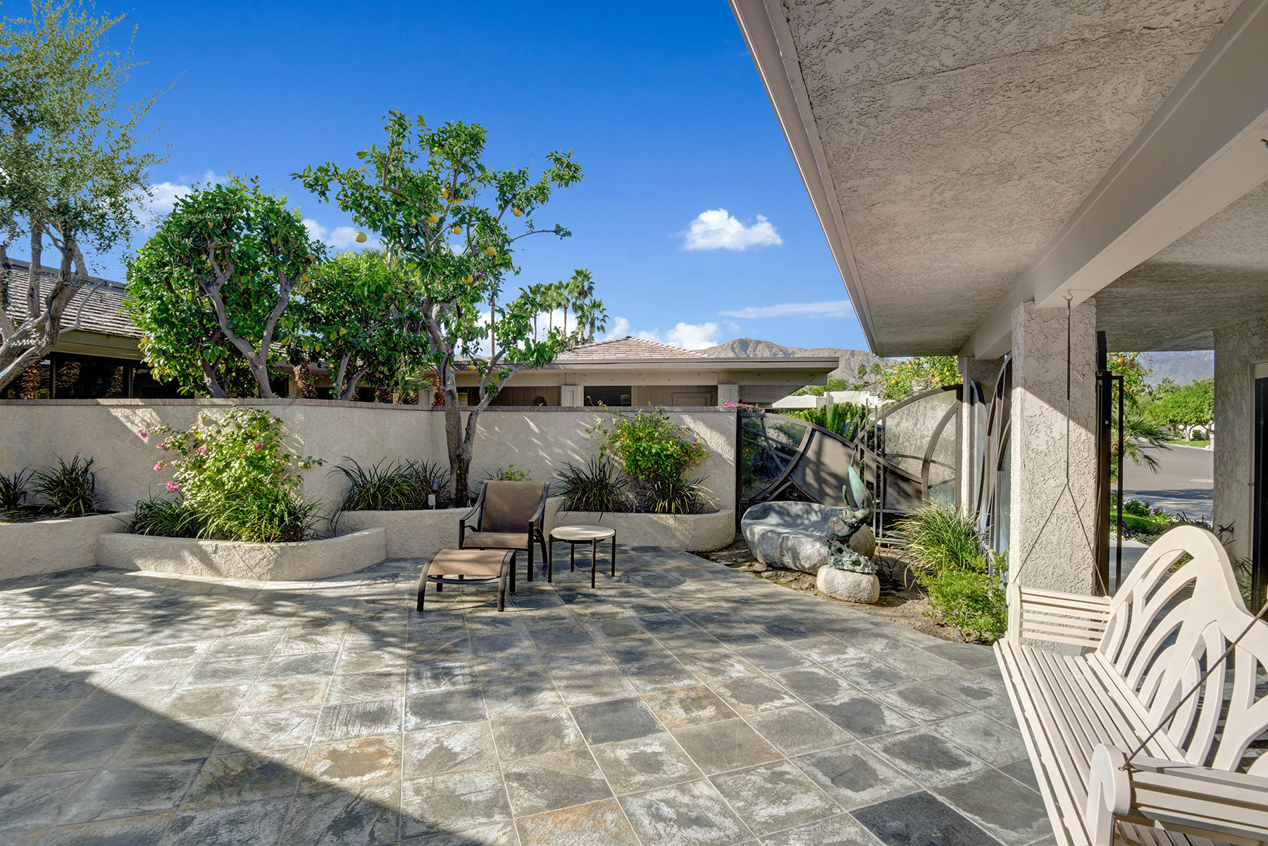 8 Rutgers Court Rancho Mirage, CA 92270 - Photo 52 of 57 a view of a patio with table and chairs potted plants and palm tree