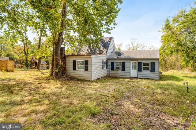 a view of a yard in front of a house with large trees