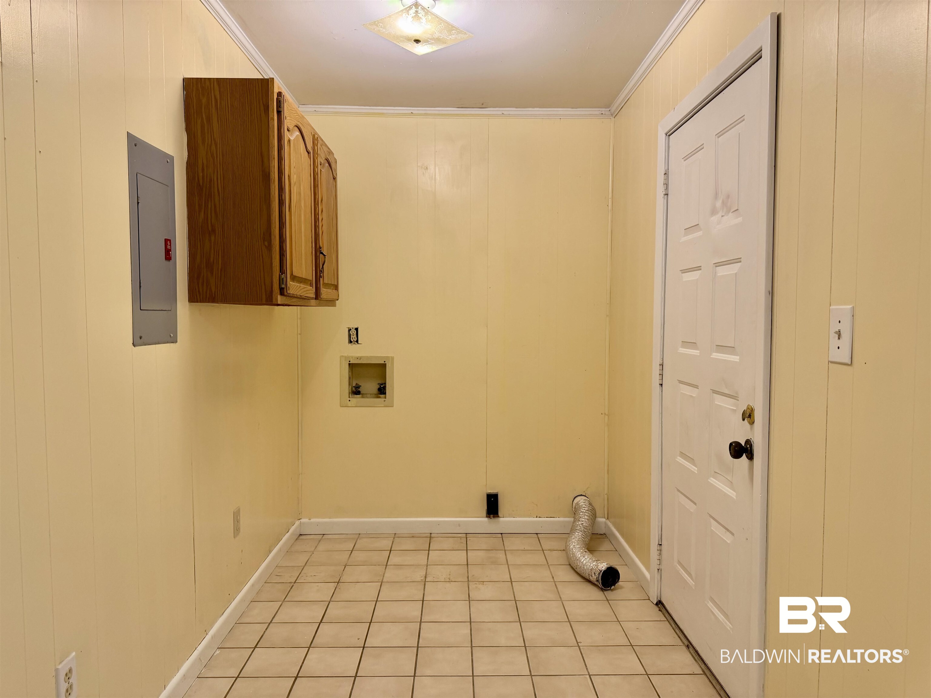 294 Wolf Log Road Flomaton, AL 36441 - Photo 13 of 14 Laundry area with wood walls, cabinet space, ornamental molding, electric panel, and hookup for a washing machine