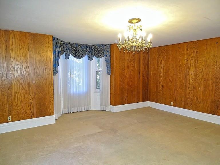 This spacious living room features a floor to ceiling window as well as a bay window and decorative fireplace.