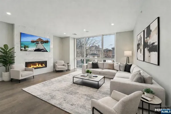 a living room with furniture fireplace and a large window