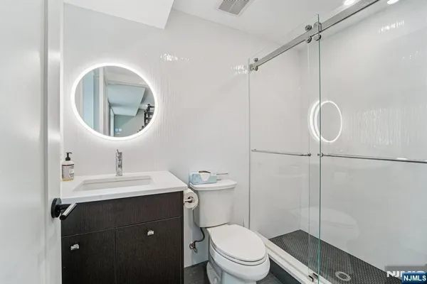 a bathroom with a toilet a sink and mirror