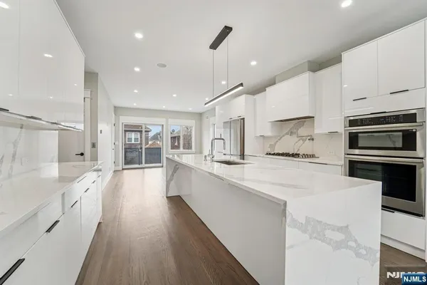 a large white kitchen with stainless steel appliances