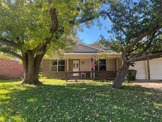 a front view of house with a garden and trees