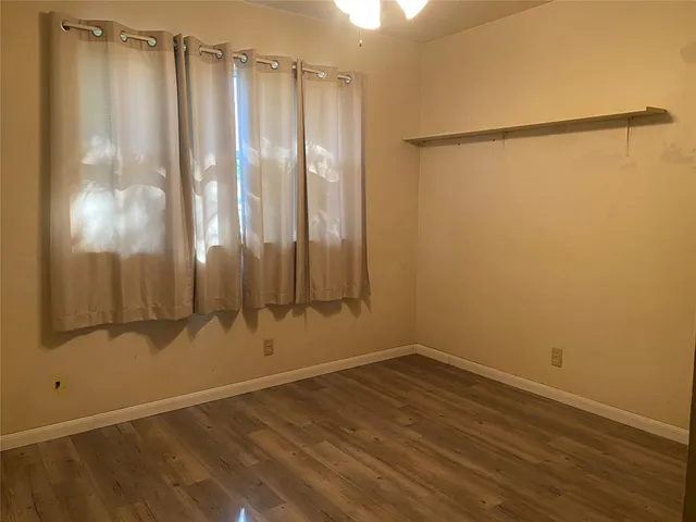 a view of a room with wooden floor and a window
